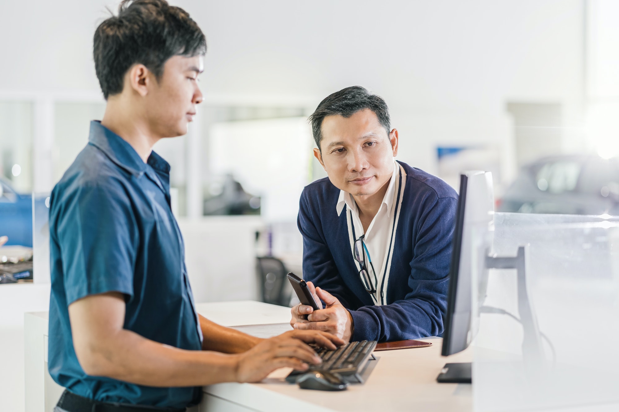 Asian mechanic typing the keyboard when service the customer for checking at maintainance service